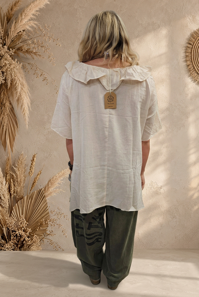 Rear-view blouse with sunlit beige backdrop